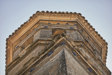 Low angle architectural detail of Baeza Cathedral stone tower in Andalusia, Spain © Goodwoon Mallorca
