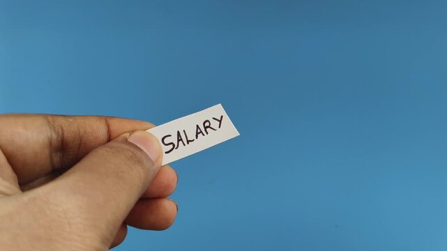 Closeup of hand holding white paper with salary increment word or text written on it cut off using scissor. Denied annual pay raise revision or no hike appraisal concept.