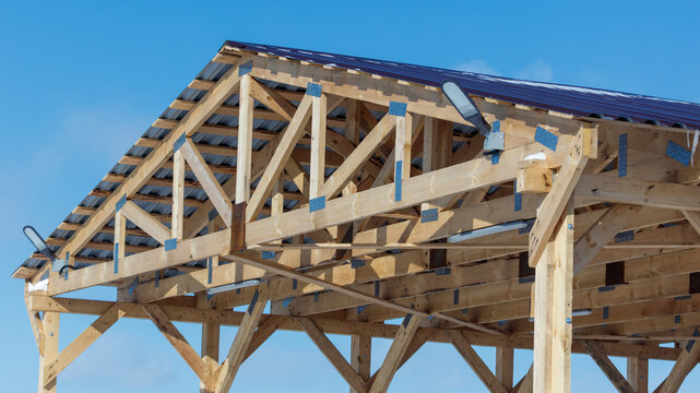 Wooden roof frame under clear blue sky