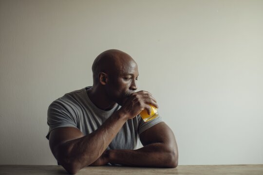 Thoughtful man enjoying a refreshing drink at a serene moment embodying relaxation and mindfulness in contemporary lifestyle. Generative AI