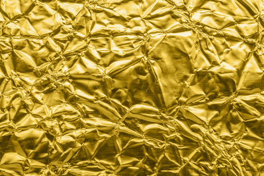 Luxury shiny metallic golden foil crumpled texture background