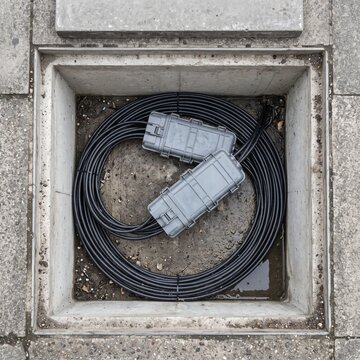 A jointing chamber opened in a footway with coiled slack inside