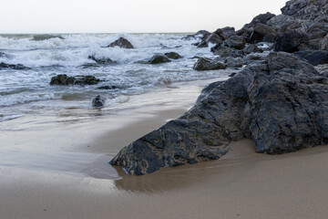 Rocky beach with breaking ocean waves and wet sand © Dimitar