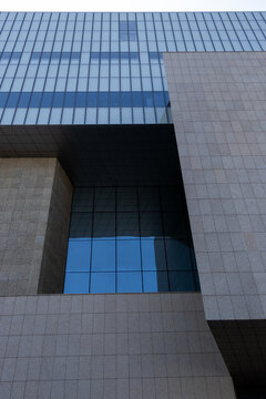Abstract modern architecture facade with stone tiles and glass windows