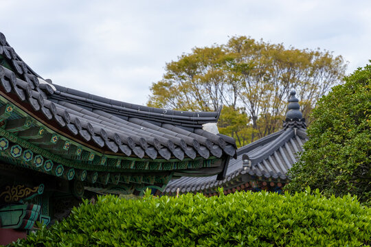 Traditional Korean temple roofs with ornate eaves and lush green foliage