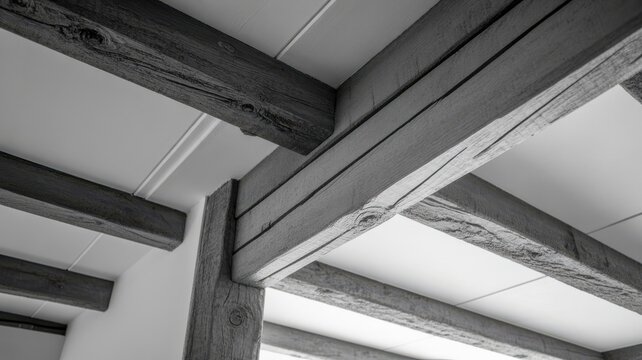 Monochrome view of rustic wooden ceiling beams in house interior.