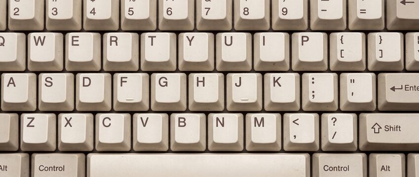 Desktop computer keyboard keys featuring classic white layout with standard qwerty characters for modern office typing operations.