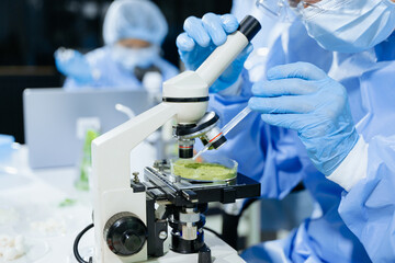 Fototapeta premium Male nutritionist in lab coat analyzing food and writing in notebook. Healthy eating, organic testing