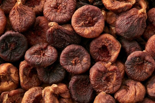 Dried figs arranged closely together in a bowl showing their shape and texture