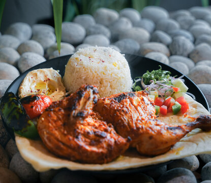 Middle Eastern kebab platter with rice and sauces, Turkish Adana and Urfa kebab platter with chicken, Delicious Turkish Kebab Platter with Grilled Meat, Rice, Salad, and hummus.