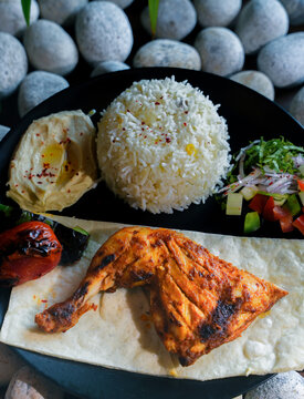 Middle Eastern kebab platter with rice and sauces, Turkish Adana and Urfa kebab platter with chicken, Delicious Turkish Kebab Platter with Grilled Meat, Rice, Salad, and hummus.