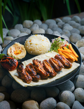 Middle Eastern kebab platter with rice and sauces, Turkish Adana and Urfa kebab platter with chicken, Delicious Turkish Kebab Platter with Grilled Meat, Rice, Salad, and hummus.