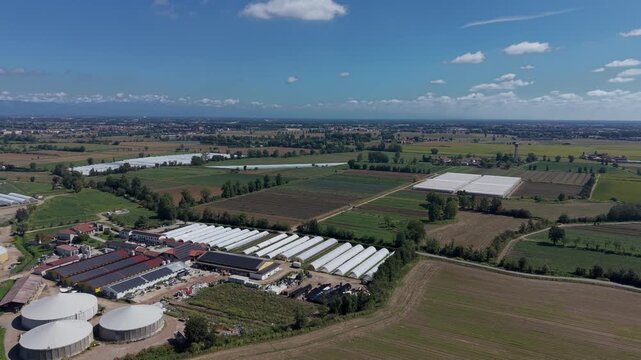 Biogas Plant and Farmland: An aerial view showcases a biogas plant with large digesters alongside agricultural fields and greenhouses.