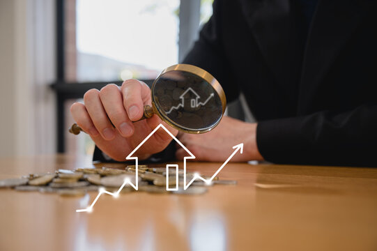 Businessman holding magnifying glass An investor studying real estate market trends with a magnifying glass real estate investment concept energy efficiency rating and property value