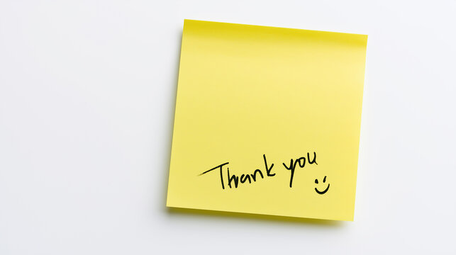A yellow square sticky note on a white background with handwritten black "Thank you" text and a smiley face symbol.
