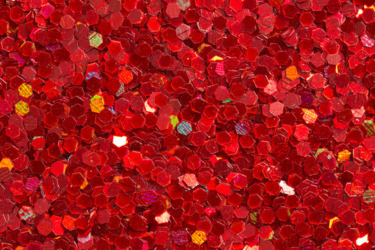 Red glitter texture with hexagonal sequins filling the frame