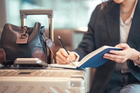 Business woman writing hand note in journal book planning for business travel at international airport terminal.