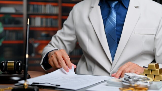 Male lawyer examines legal documents inside office, experienced lawyer seeking justice as corporate lawyer fights corruption, bringing legal justice regarding bribery.