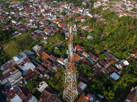 Aerial View of Large Telecommunication Tower Standing Amid a Densely Populated Rural Settlement in Baturaden, Indonesia. 