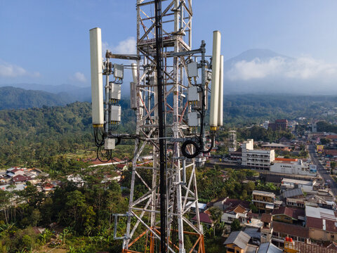 Aerial View of Steel Structures and Multiple Antennas on a Telecommunication Tower in a Rural Settlement in Indonesia.