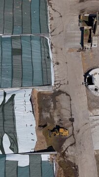 Aerial view of a tractor loading silage for biomethane production at an Italian farm, illustrating renewable energy, agricultural resources and modern farming.