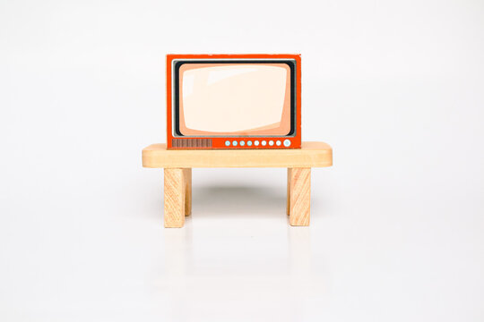 Miniature retro television set on a wooden stand, isolated on a white background, dollhouse furniture