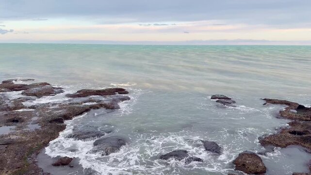 Waves Crashing on Rocky Coastline at Sunset 