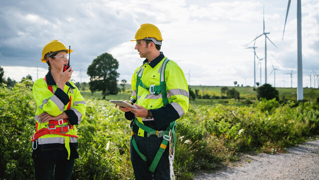 Two engineers in high-visibility gear stand beside a dirt path