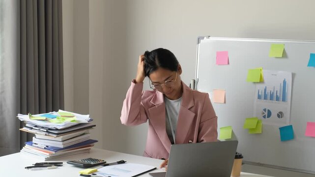 Asian businesswoman suffering from headache stress while overworking with laptop, calculator and document stack for corporate burnout, financial workload pressure and health concept
