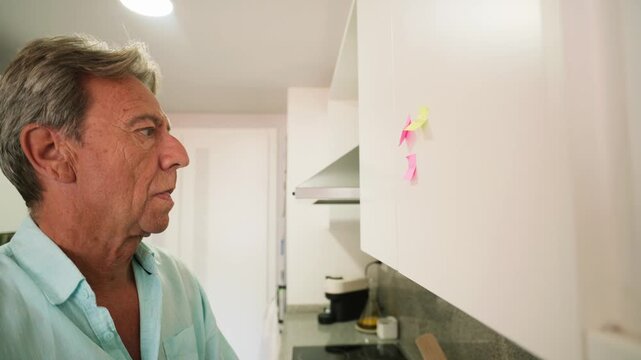 Retired senior man with memory loss pointing at sticky notes