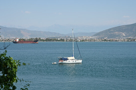 A white sailing yacht sails through a dark blue bay
