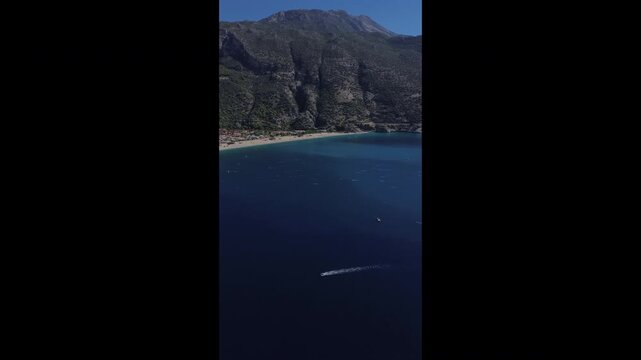 Highspeed boat racing across bright turquoise bay shoreline