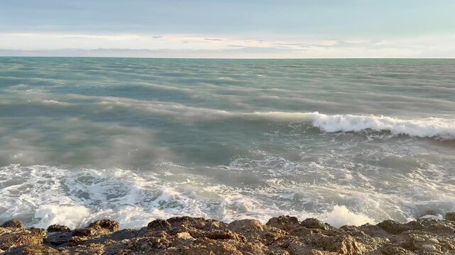 Waves Crashing on Rocky Coastline at Sunset 