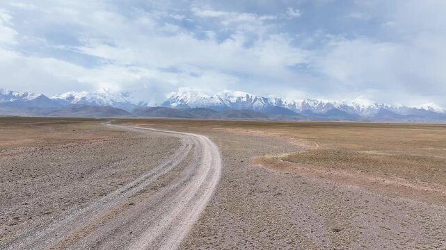 Aerial video, Drone Follows Dirt Road to Lenin Peak Base Camp, Pamir Mountains