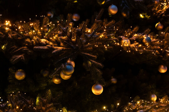 Decorated Christmas tree with golden ornaments and lights at night in a festive setting