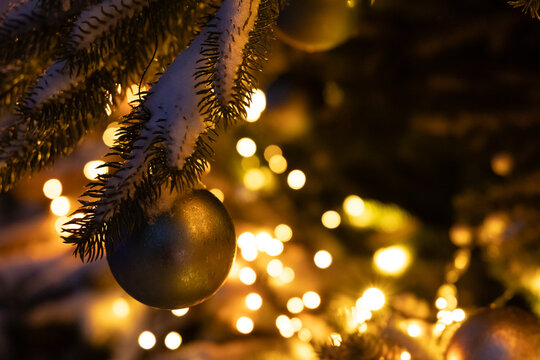 Christmas tree with ornaments and lights during evening time in winter season