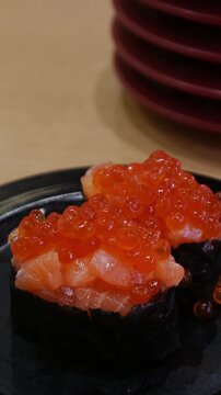 Salmon Roe Gunkan Sushi with Ikura on Black Plate, Japanese Seafood Delicacy
