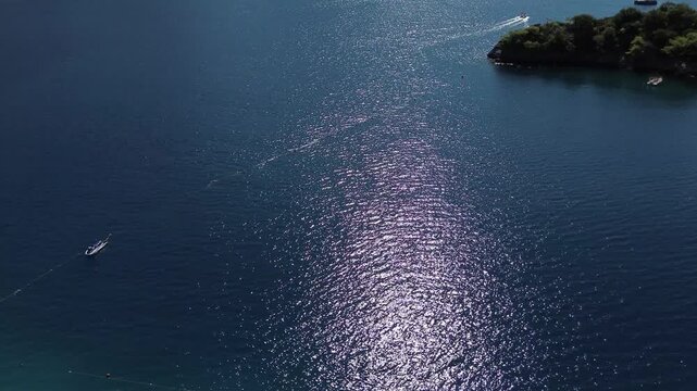Sparkling ocean view showing boat trailing near small island