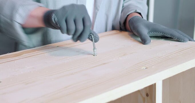 A man assembling a wooden bookshelf