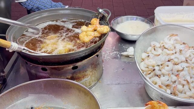 Korean Street Food &ndash; Deep Fried Shrimp in Crispy Batter Sizzling in Hot Oil at Outdoor Night Market Stall