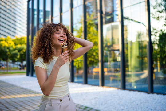 Happy woman enjoying ice cream on city street