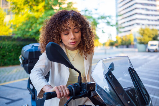 Young woman commuting on motorcycle in city street