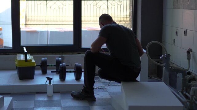 Highly engaging commercial ready closeup video of a worker applying polyurethane foam adhesive from a spray can onto a styrofoam panel for floor insulation.