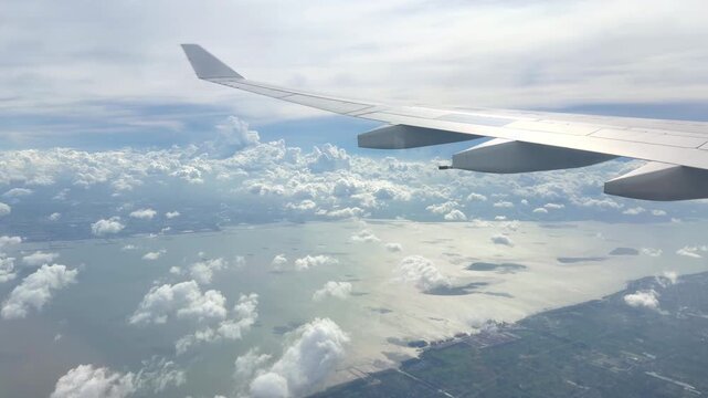 View from Airplane Window Looking Down at Clouds &ndash; Aerial Perspective of Fluffy White Clouds Over Blue Sky
