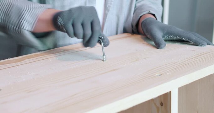 A man assembling a wooden bookshelf