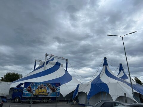 Ulyanovsk, Russia, August 16, 2026. The blue-and-white circus tent of the Gartner brothers against a gray, cloudy sky. The word "Circus" in Russian