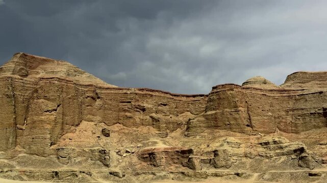Majestic Yardang landform of Urho Ghost City under a dramatic cloudy sky in Karamay, Xinjiang, China.