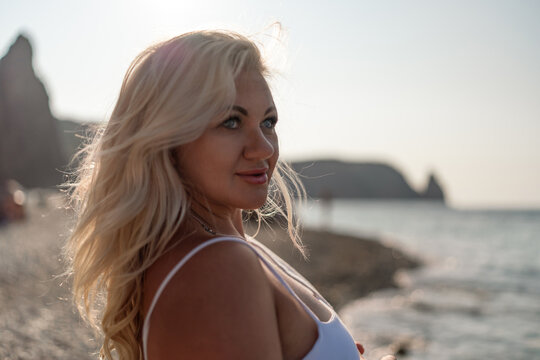 Beautiful woman, blonde hair, beach, vacation, enjoying serene sunset moment by the sea