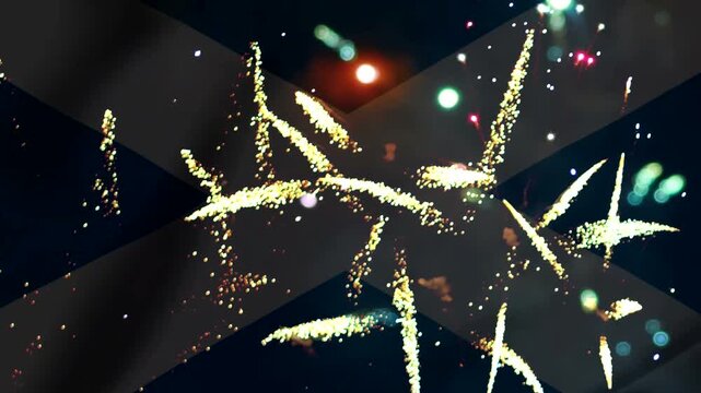 Bright colorful fireworks exploding in the night sky over the flag of scotland