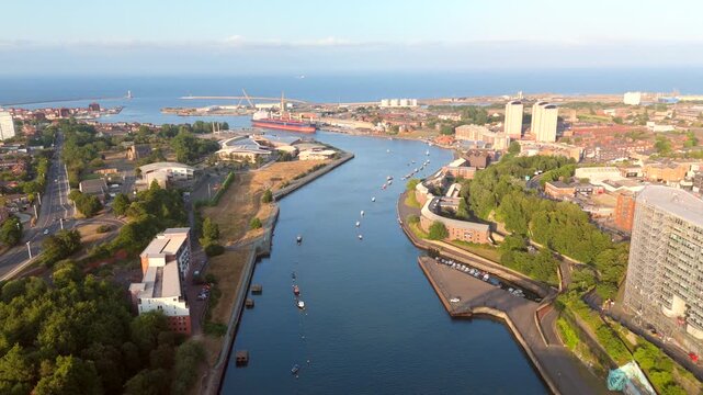 Sunderland UK: 17th July 2026: Drone vertical pan of Sunderland River wear and Port at golden hour. Wearmouth Bridge and the Monkwearmouth Railway Bridge at sunset